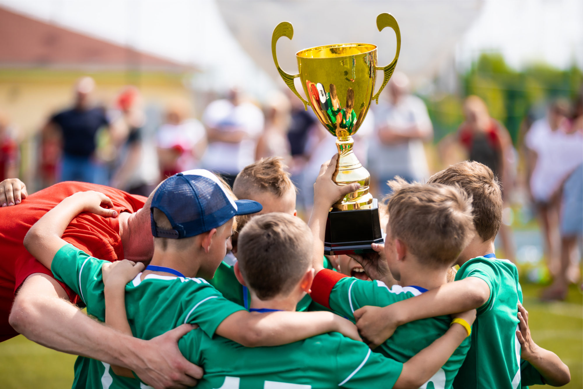 Young Soccer Players Holding Trophy. Boys Celebrating Soccer Football Championship. Winning team of sport tournament for kids children.